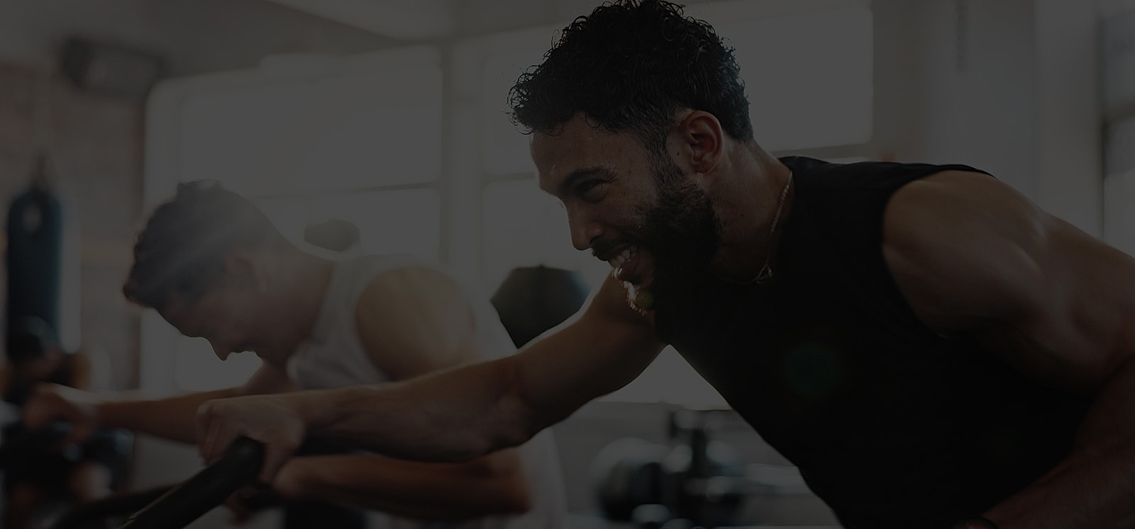 Men exercising intensely in a gym setting.