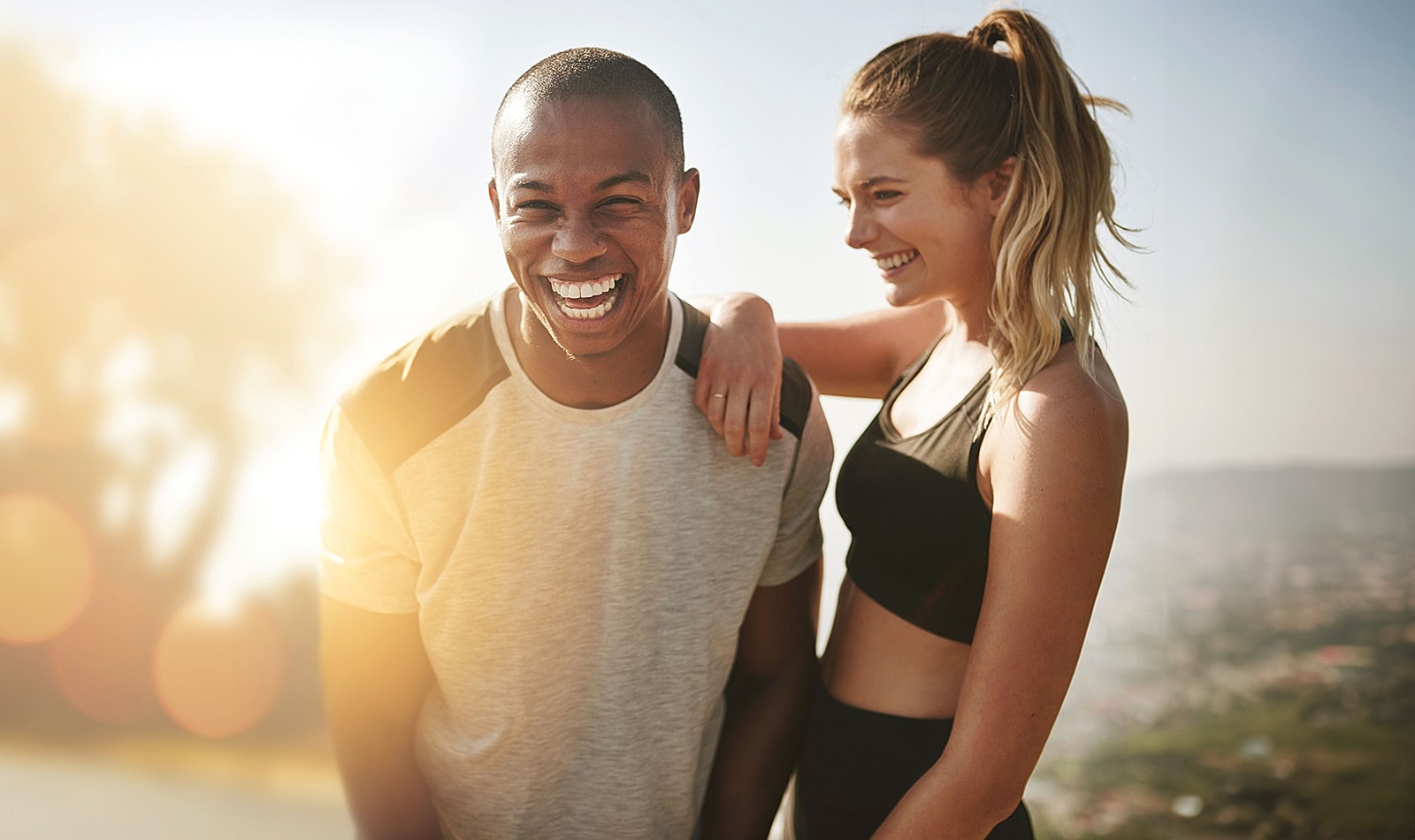 Man jogging outdoors at sunrise near water.